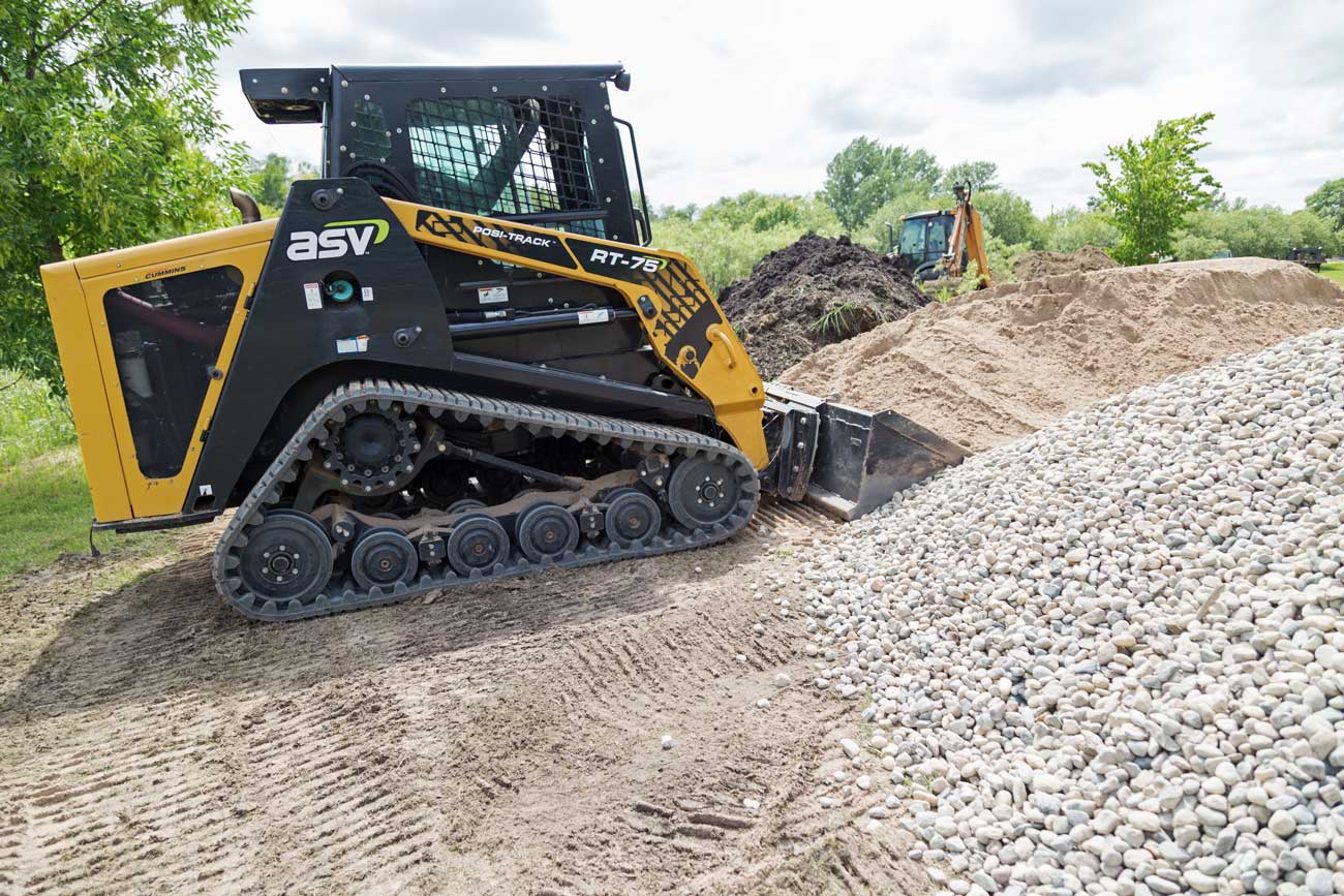 Skid steer grader leveling soil during residential lot grading in Charlotte