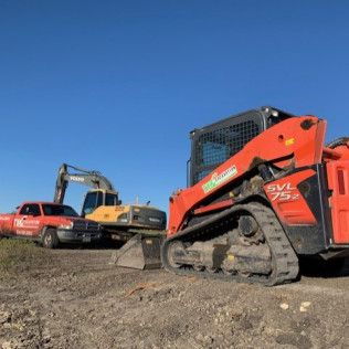 Skid steer clearing brush and debris during land clearing in Charlotte
