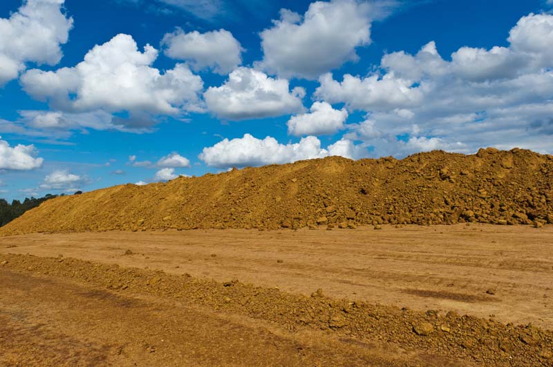 Dump trucks hauling fill dirt from a Charlotte excavation site
