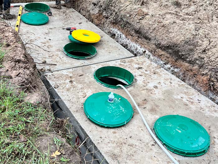 Septic tank set in excavated hole during installation in Charlotte