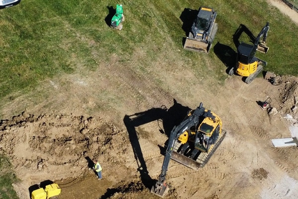 Aerial view of excavators and equipment preparing a commercial building site in Charlotte, NC
